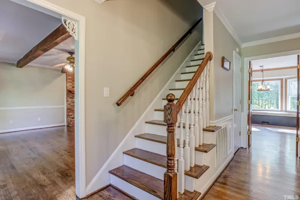 a view of staircase with wooden floor and white walls