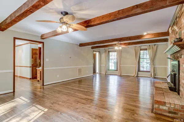 a view of a livingroom with wooden floor and a ceiling fan