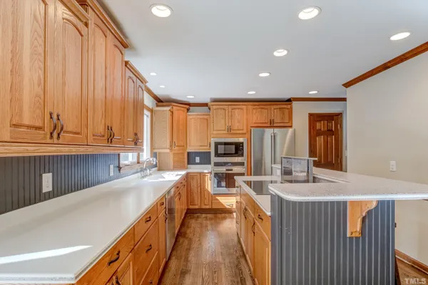 a view of a kitchen with kitchen island granite countertop a large window a sink and a counter top space