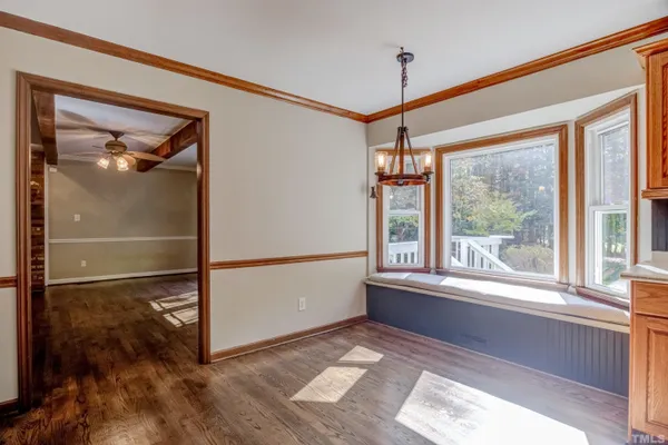 a view of a room with window wooden floor and front door