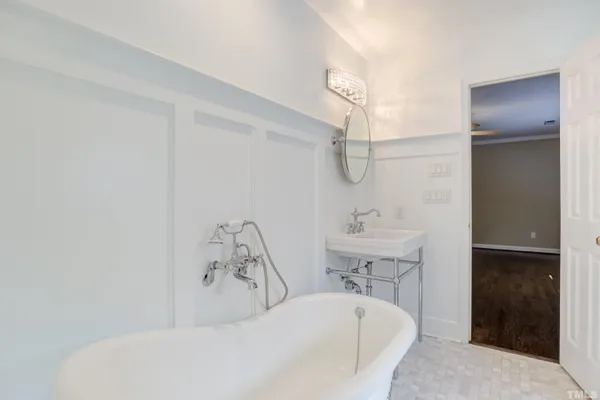 a bathroom with a tub sink a mirror and shower