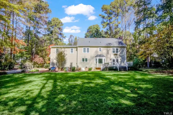 a view of a house with a big yard and large trees