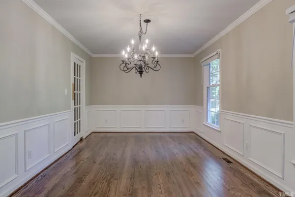 a view of a room with wooden floors and chandelier