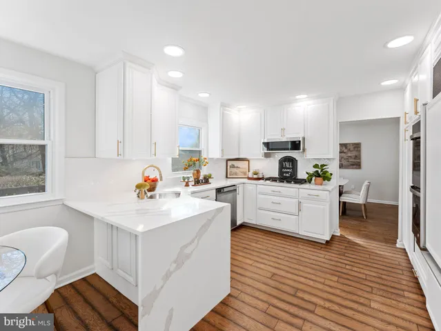 a kitchen with white cabinets and stainless steel appliances