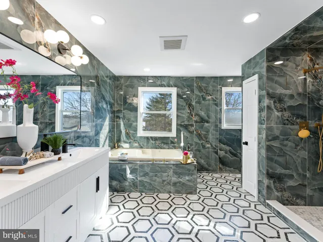 a bathroom with a sink a toilet a mirror and a window