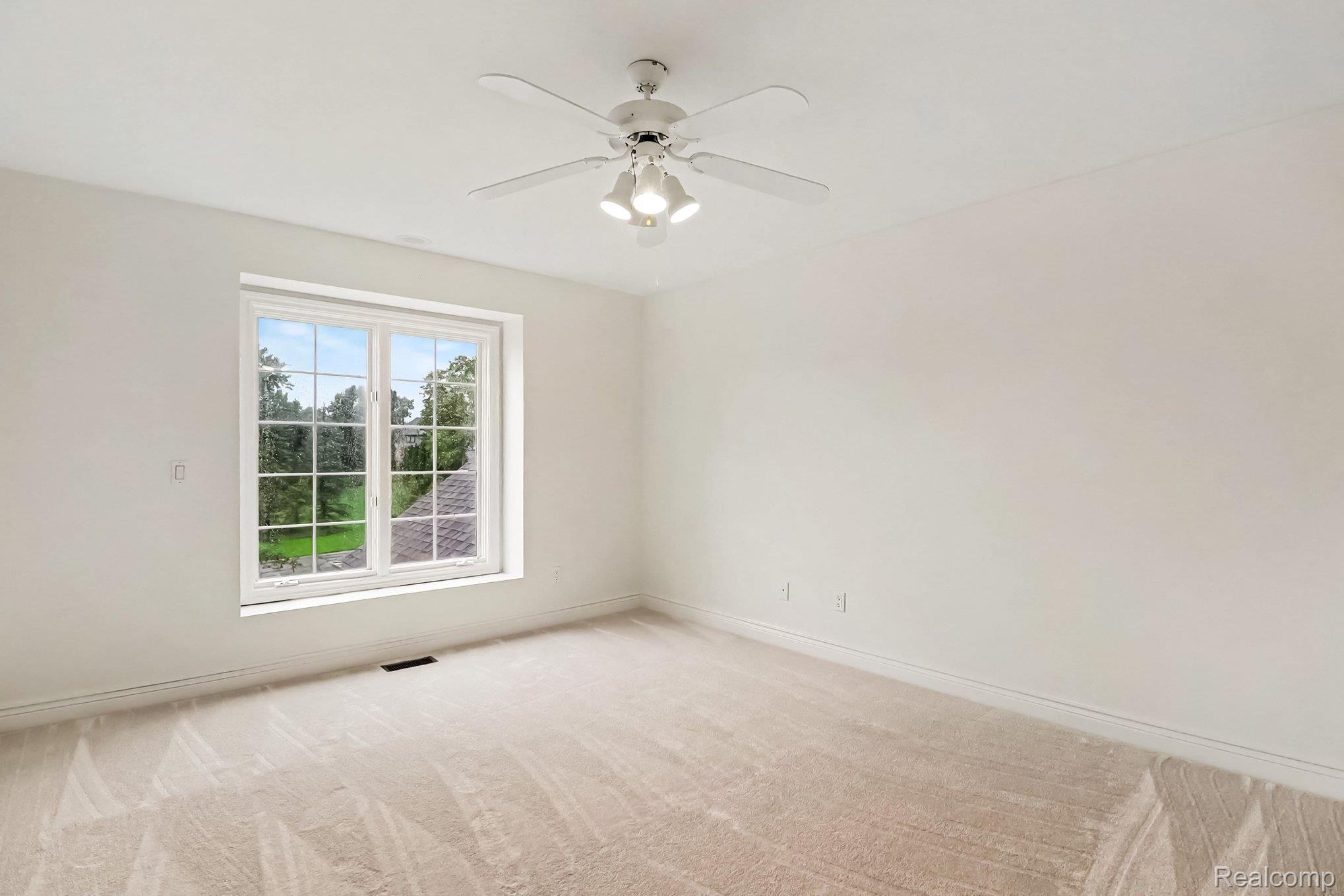 4875 Green Meadow Lane Rochester, MI 48306 - Photo 26 of 60 Carpeted room with a ceiling fan, a window with muntins, and white walls