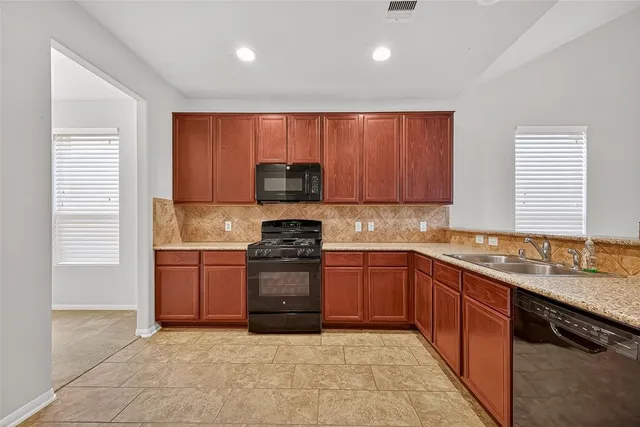 a kitchen with stainless steel appliances granite countertop a sink stove and cabinets