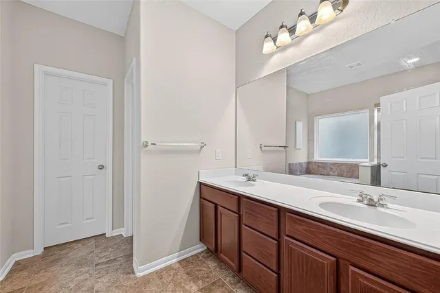 a bathroom with a double vanity sink and a mirror