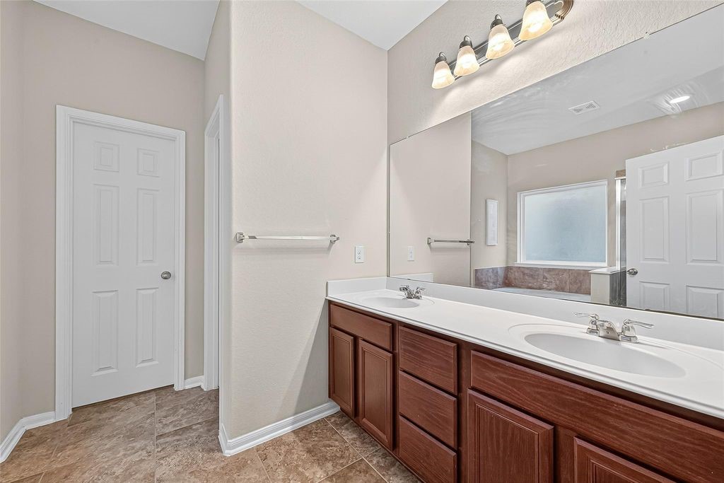 3218 Dappled Vale Trail Spring, TX 77373 - Photo 25 of 47 a bathroom with a double vanity sink and a mirror