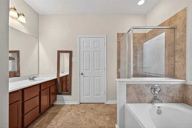 a bathroom with a tub sink and mirror