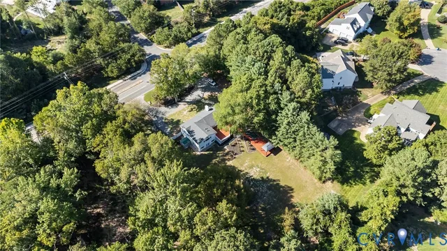 an aerial view of residential houses with outdoor space and trees
