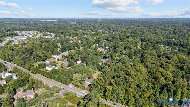an aerial view of a residential houses with outdoor space and trees
