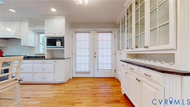 a kitchen with stainless steel appliances granite countertop a stove and white cabinets