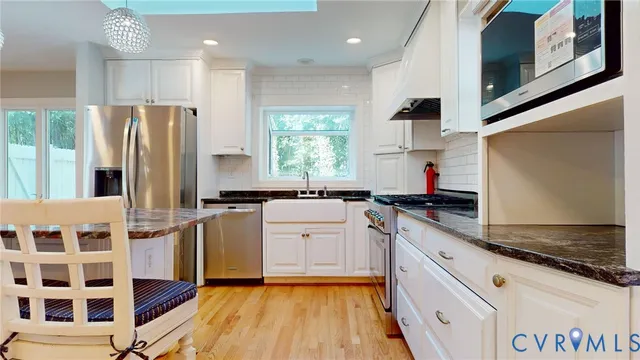 a kitchen with stainless steel appliances granite countertop a stove a sink and a refrigerator