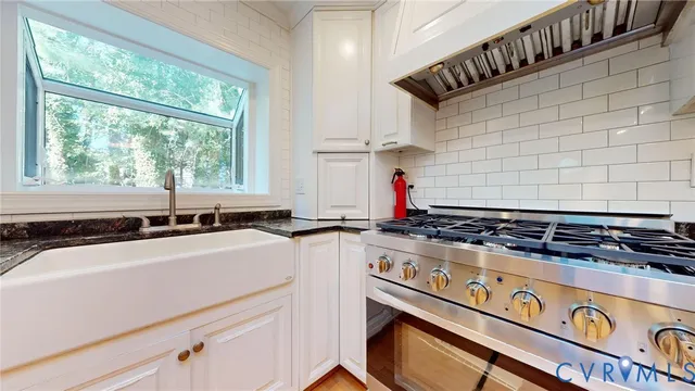 a kitchen with stainless steel appliances a sink stove and cabinets