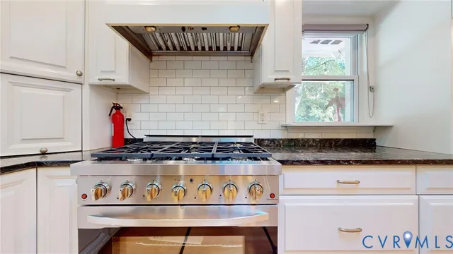 a kitchen with granite countertop a stove a sink and a counter