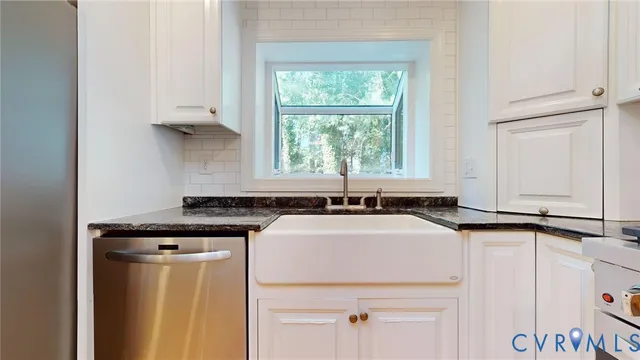a kitchen with stainless steel appliances granite countertop a sink stove and white cabinets