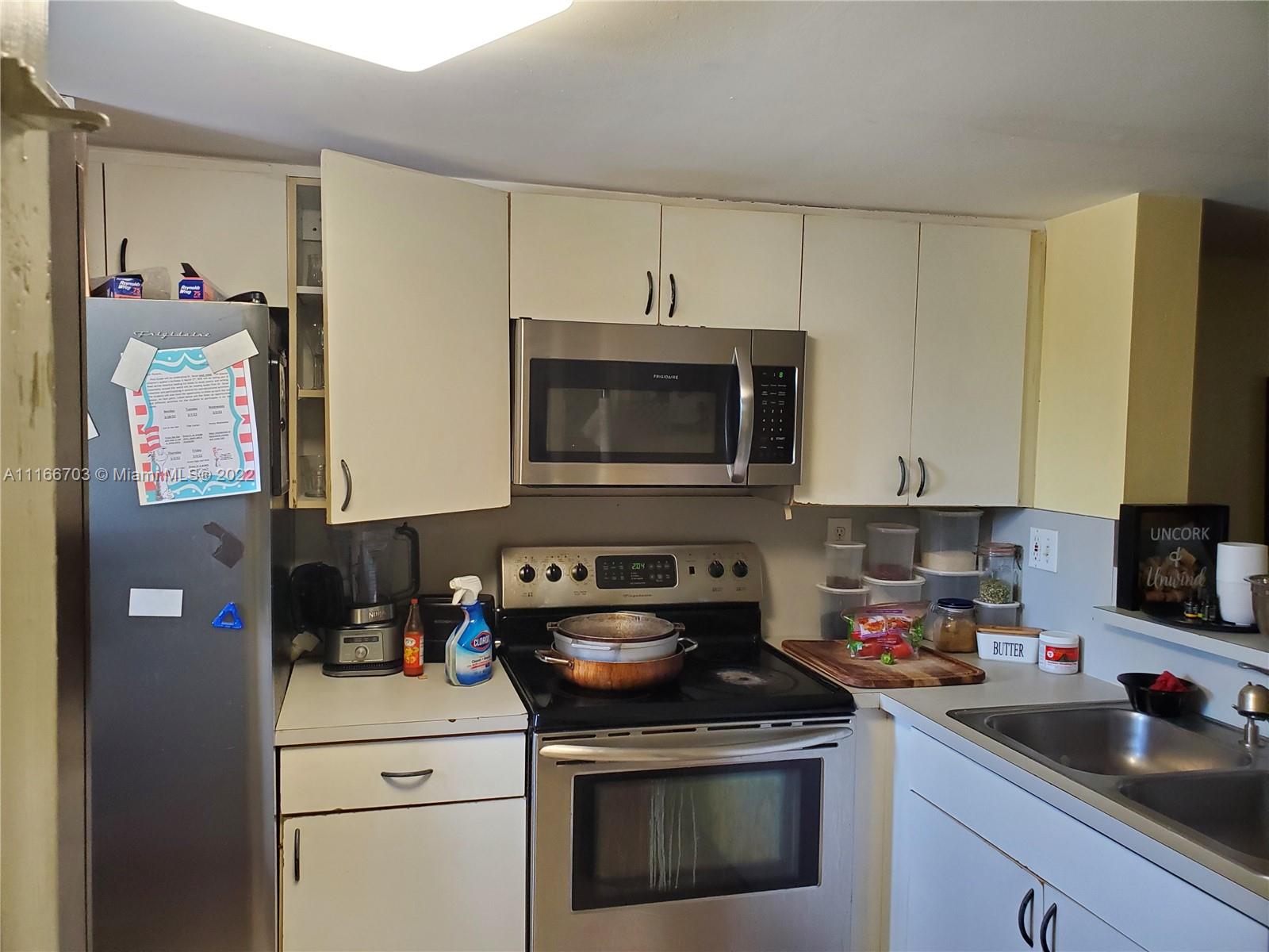 14010 Northeast 3rd Court, Unit 1 Miami, FL 33161 - Photo 2 of 6 a kitchen with stainless steel appliances a stove a microwave and cabinets