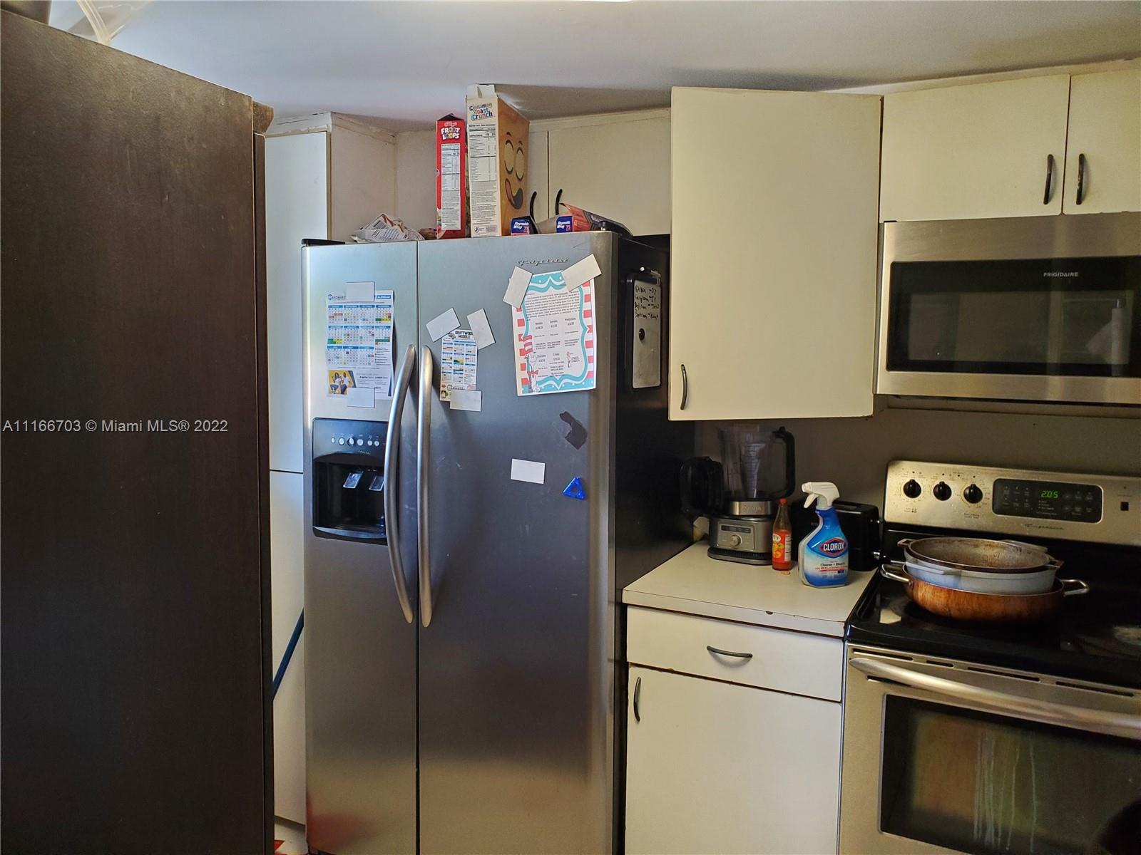 14010 Northeast 3rd Court, Unit 1 Miami, FL 33161 - Photo 3 of 6 a kitchen with stainless steel appliances a refrigerator a stove and a microwave