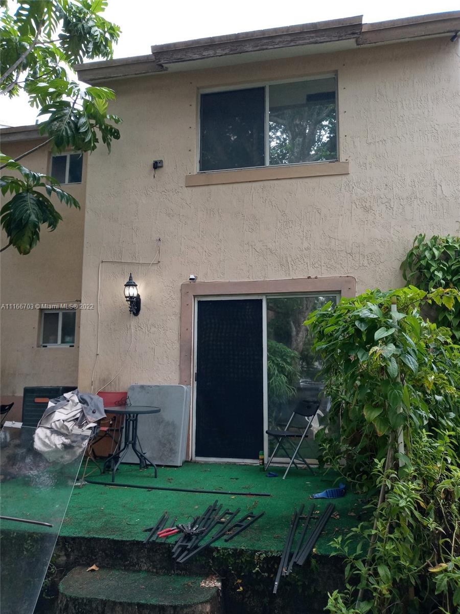 14010 Northeast 3rd Court, Unit 1 Miami, FL 33161 - Photo 4 of 6 a backyard of a house with table and chairs