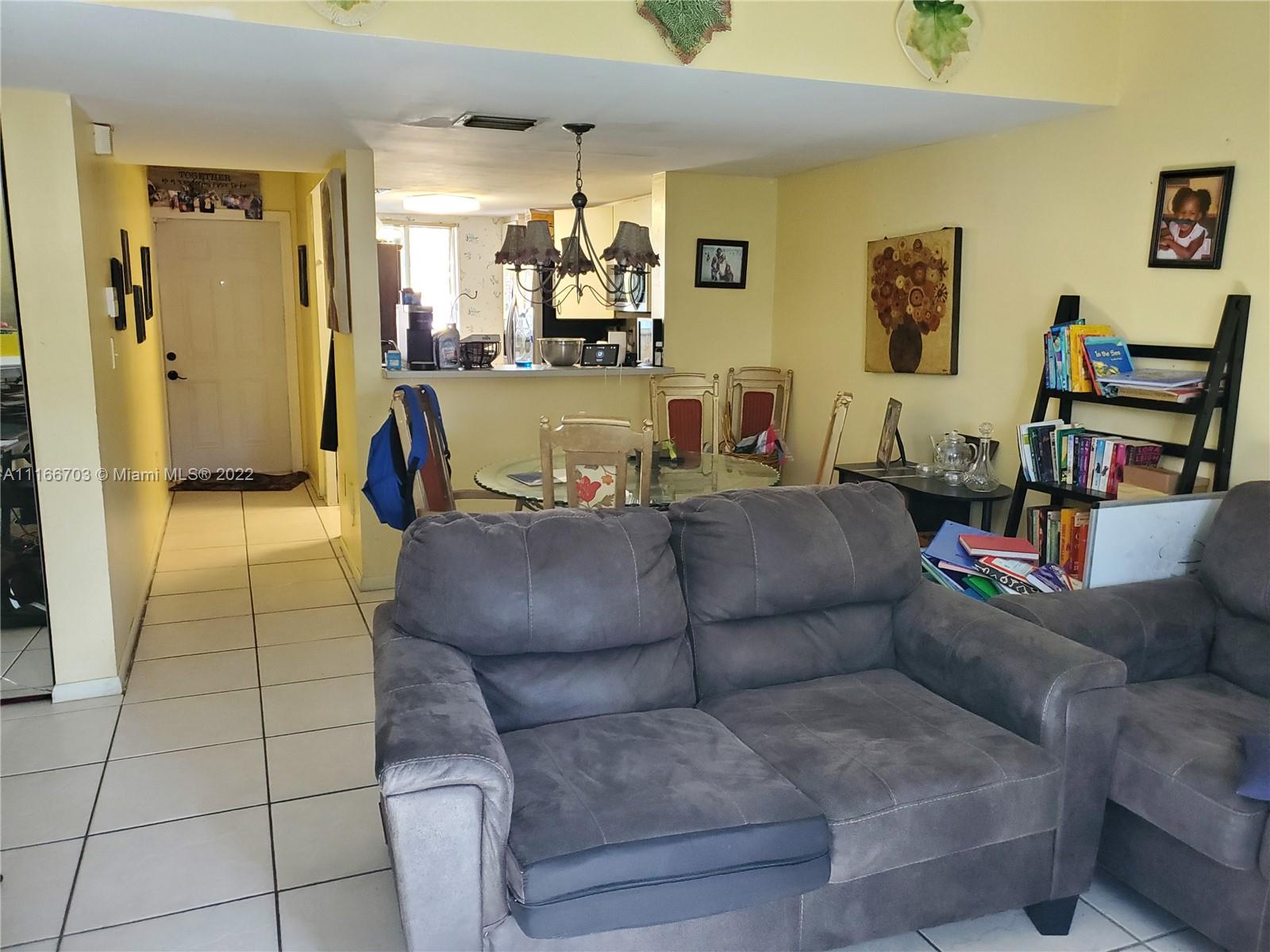 14010 Northeast 3rd Court, Unit 1 Miami, FL 33161 - Photo 5 of 6 a living room with furniture and a flat screen tv