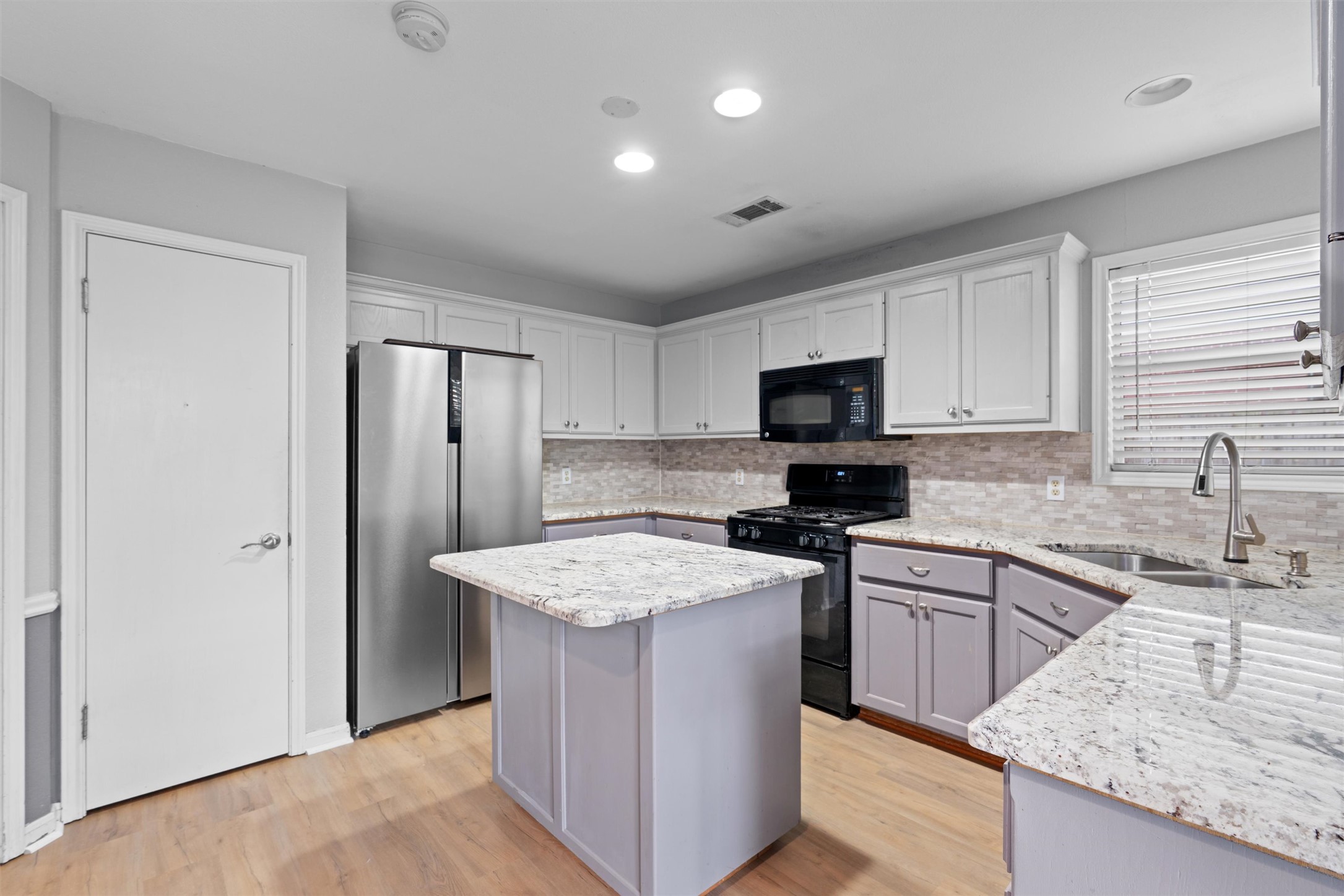 2306 Raintree Path Round Rock, TX 78664 - Photo 12 of 23 A well-appointed kitchen features a central island, gas range, and ample granite counter space.