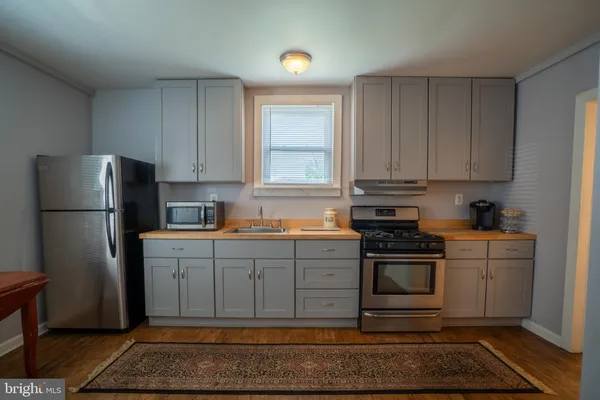 a kitchen with stainless steel appliances granite countertop a refrigerator stove and cabinets