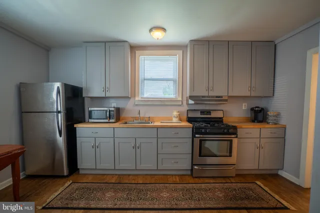a kitchen with stainless steel appliances granite countertop a refrigerator stove and cabinets
