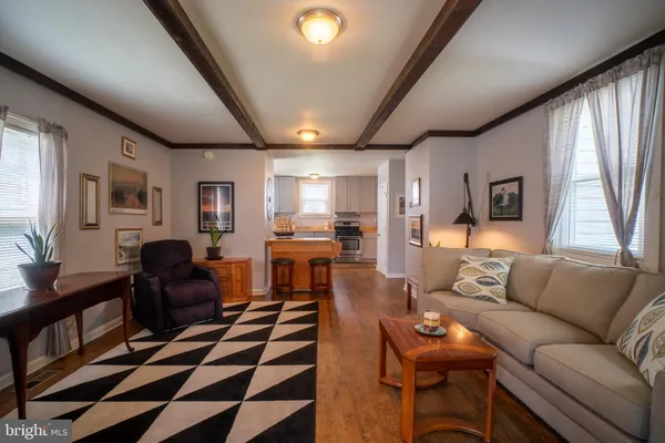a living room with furniture and a dining table with wooden floor