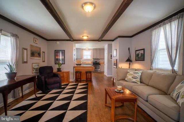 a living room with furniture and a dining table with wooden floor