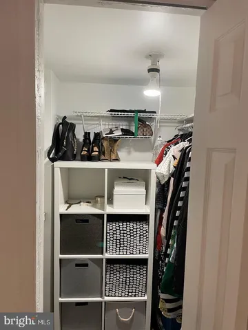 a view of walk in closet with clothes and shoes