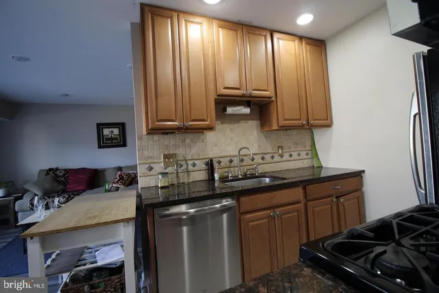 a kitchen with granite countertop a sink stove and cabinets