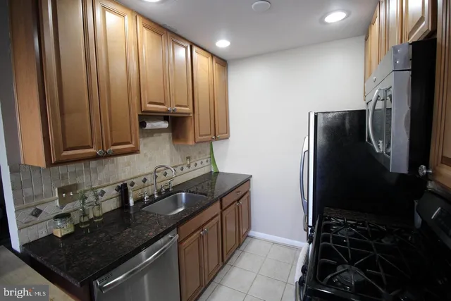 a kitchen with granite countertop a refrigerator and a sink