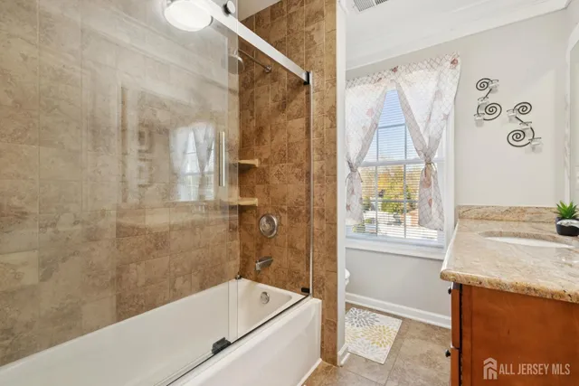 a bathroom with a granite countertop sink a toilet and shower