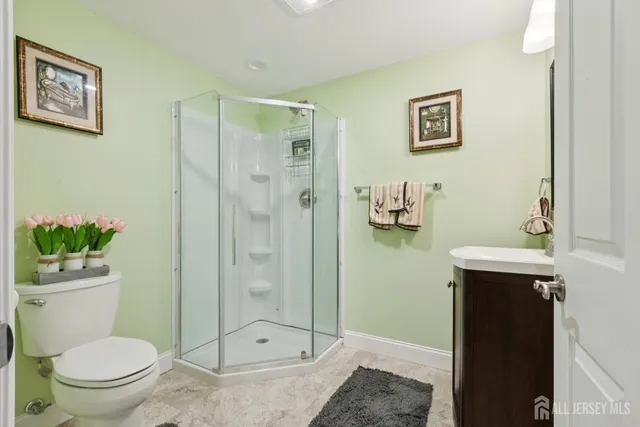 a bathroom with a granite countertop toilet a sink and shower