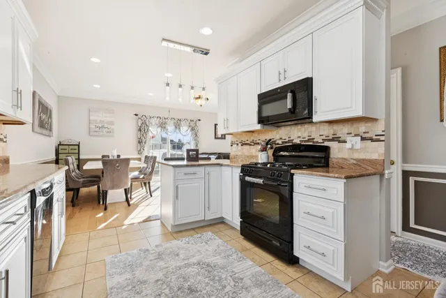 a kitchen with stainless steel appliances granite countertop a stove top oven a sink dishwasher a dining table and chairs with wooden floor