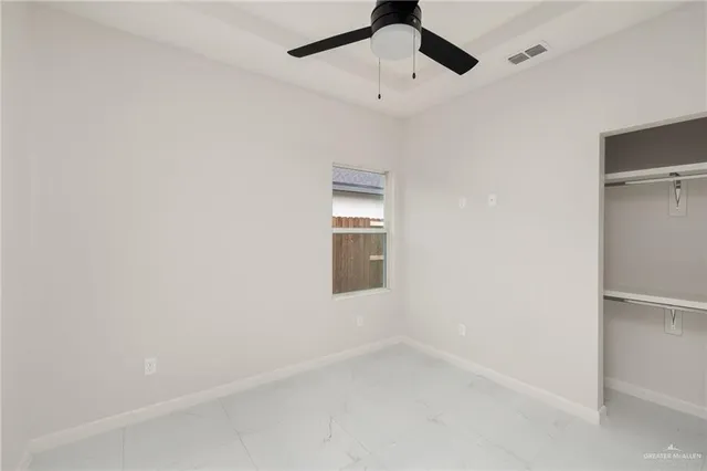 an empty room with a empty space and a ceiling fan