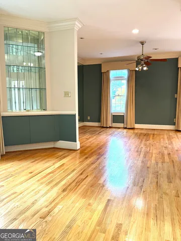 a view of an empty room with window and wooden floor