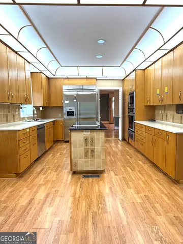 a large kitchen with stainless steel appliances kitchen island granite countertop a large counter top and sink