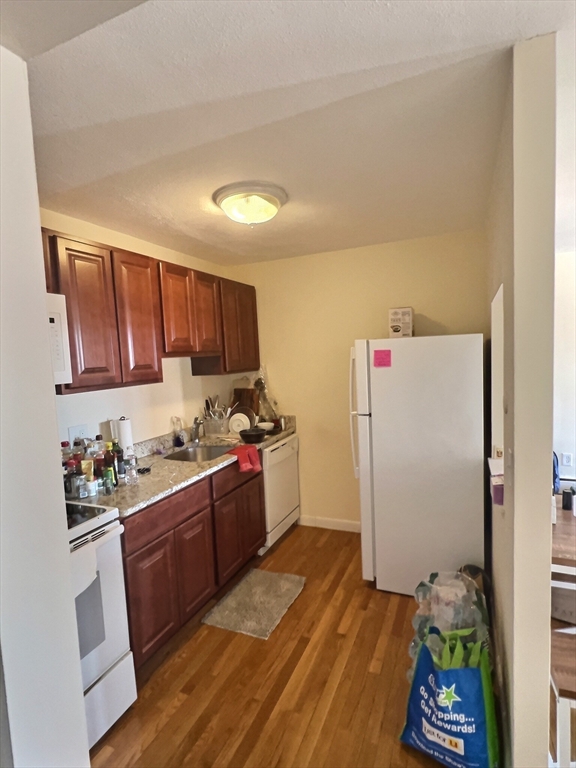 1027 Commonwealth Avenue, Unit 32 Boston, MA 02215 - Photo 2 of 8 a kitchen with sink cabinets and wooden floor