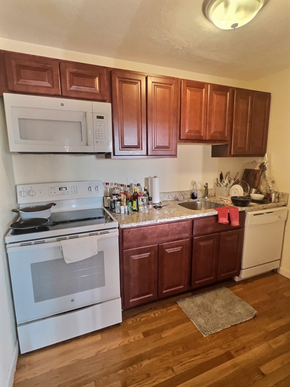 1027 Commonwealth Avenue, Unit 32 Boston, MA 02215 - Photo 3 of 8 a kitchen with granite countertop wooden cabinets and stainless steel appliances