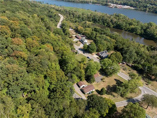 an aerial view of residential house with outdoor space and trees all around