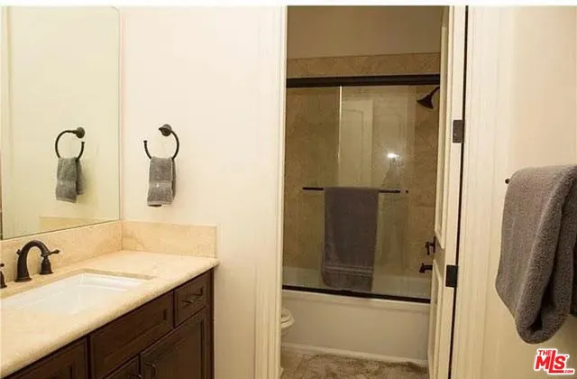 a bathroom with a shower sink and mirror