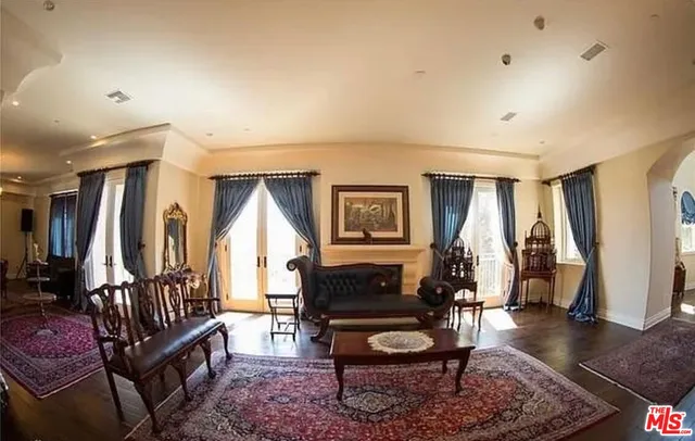 a living room with furniture a wooden floor and a large window