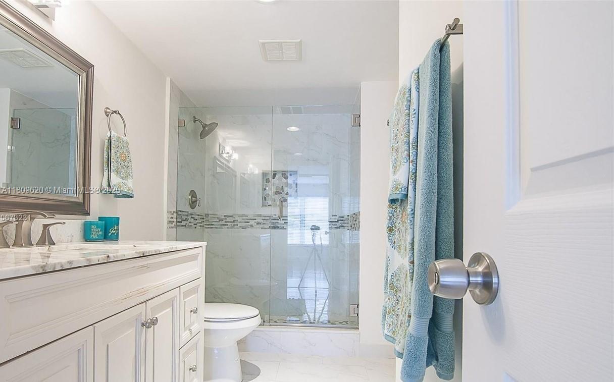 4156 Inverrary Drive, Unit 204 Lauderhill, FL 33319 - Photo 6 of 10 a bathroom with a sink a toilet a mirror and shower