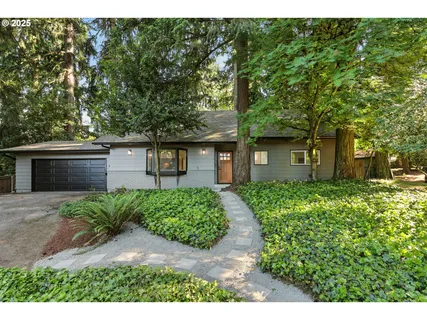 a front view of a house with a yard and shrubs
