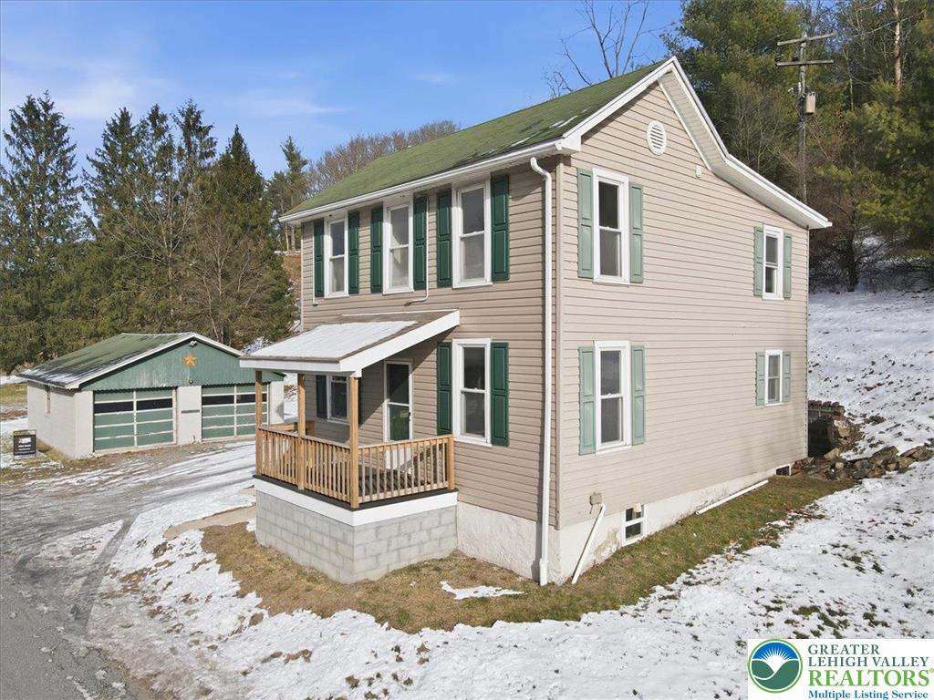 1032 Clamtown Road New Ringgold, PA 17960 - Photo 4 of 68 a view of a white house with a yard covered in snow
