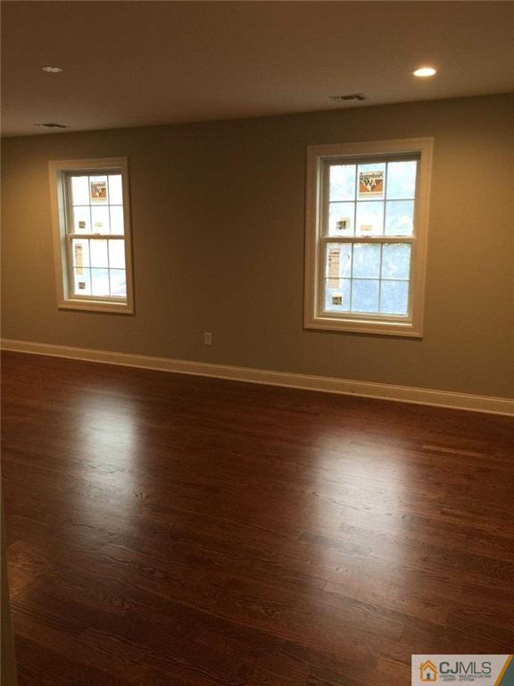 216 Oxford Road Edison, NJ 08820 - Photo 11 of 13 an empty room with wooden floor and windows