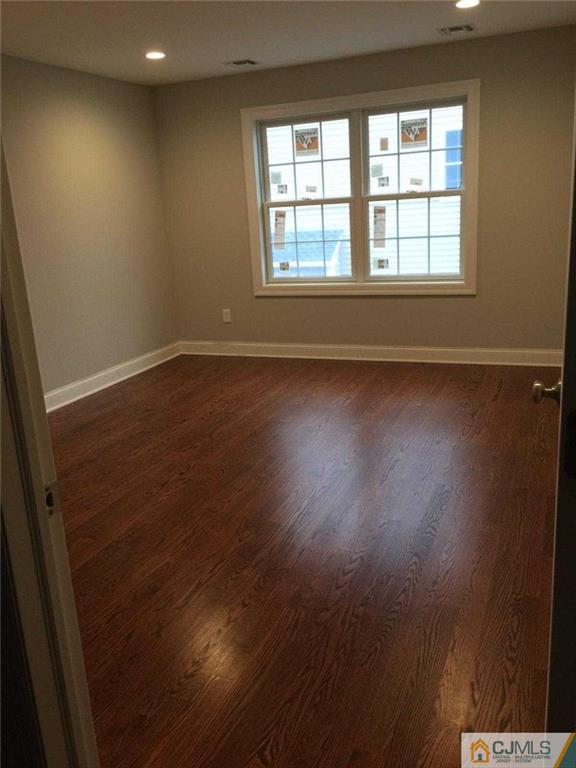 216 Oxford Road Edison, NJ 08820 - Photo 12 of 13 an empty room with wooden floor and windows