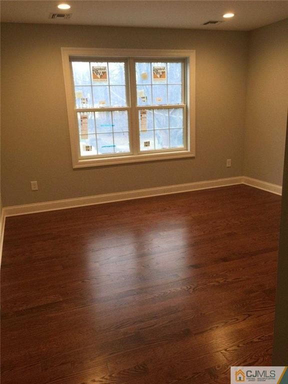 216 Oxford Road Edison, NJ 08820 - Photo 13 of 13 a view of an empty room with wooden floor and a window